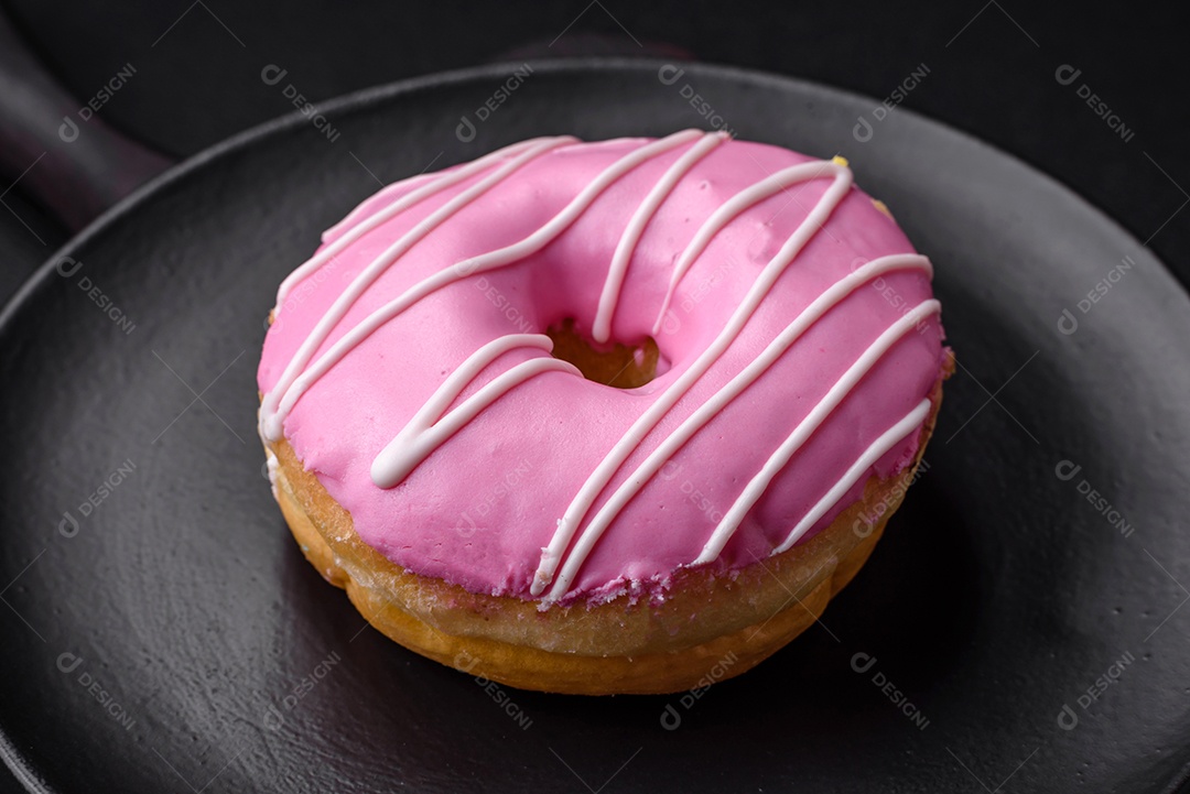 Delicioso donut com recheio de creme e nozes em um fundo escuro de concreto. Comida doce