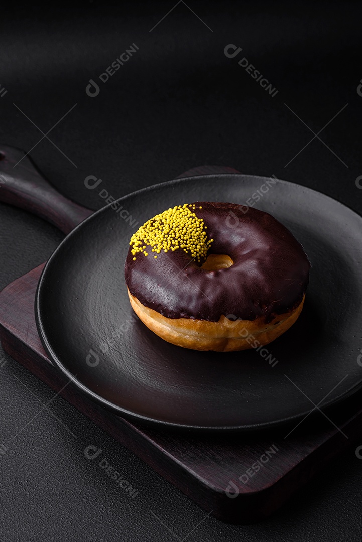 Delicioso donut com recheio de creme e nozes em um fundo escuro de concreto. Comida doce