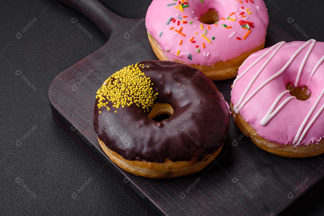 Delicioso donut com recheio de creme e nozes em um fundo escuro de concreto. Comida doce