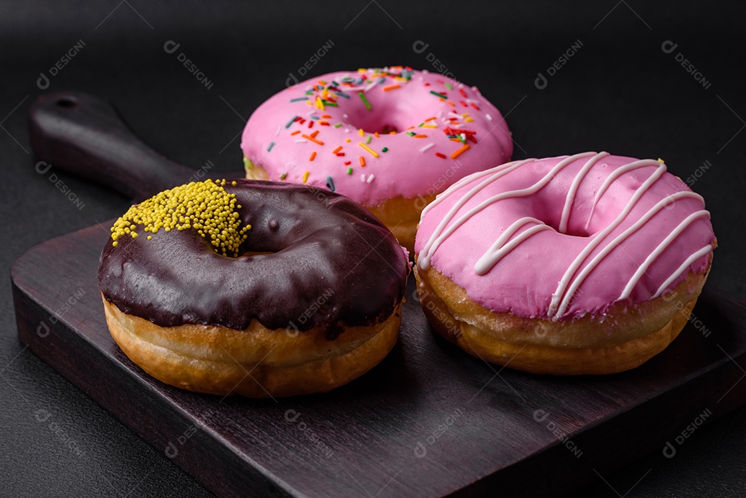 Delicioso donut com recheio de creme e nozes em um fundo escuro de concreto. Comida doce
