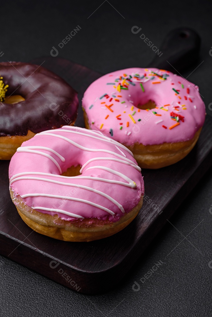Delicioso donut com recheio de creme e nozes em um fundo escuro de concreto. Comida doce