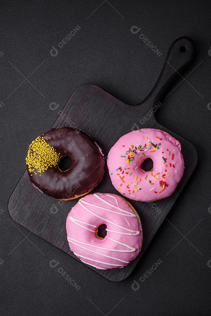 Delicioso donut com recheio de creme e nozes em um fundo escuro de concreto. Comida doce