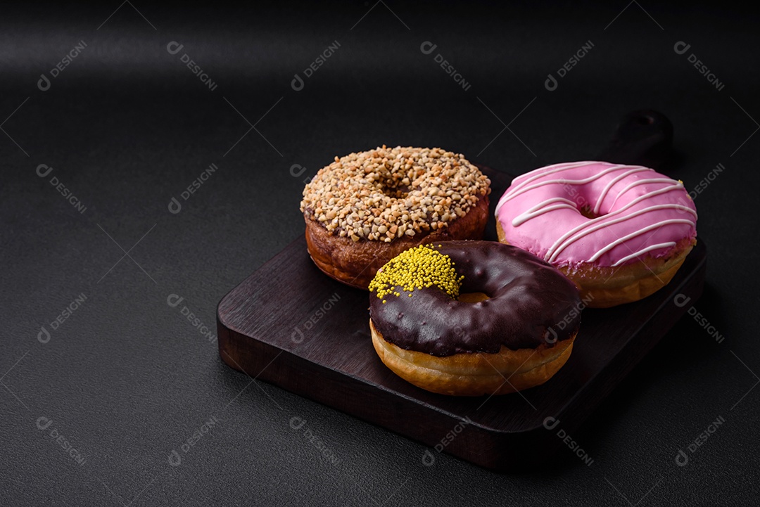 Delicioso donut com recheio de creme e nozes em um fundo escuro de concreto. Comida doce