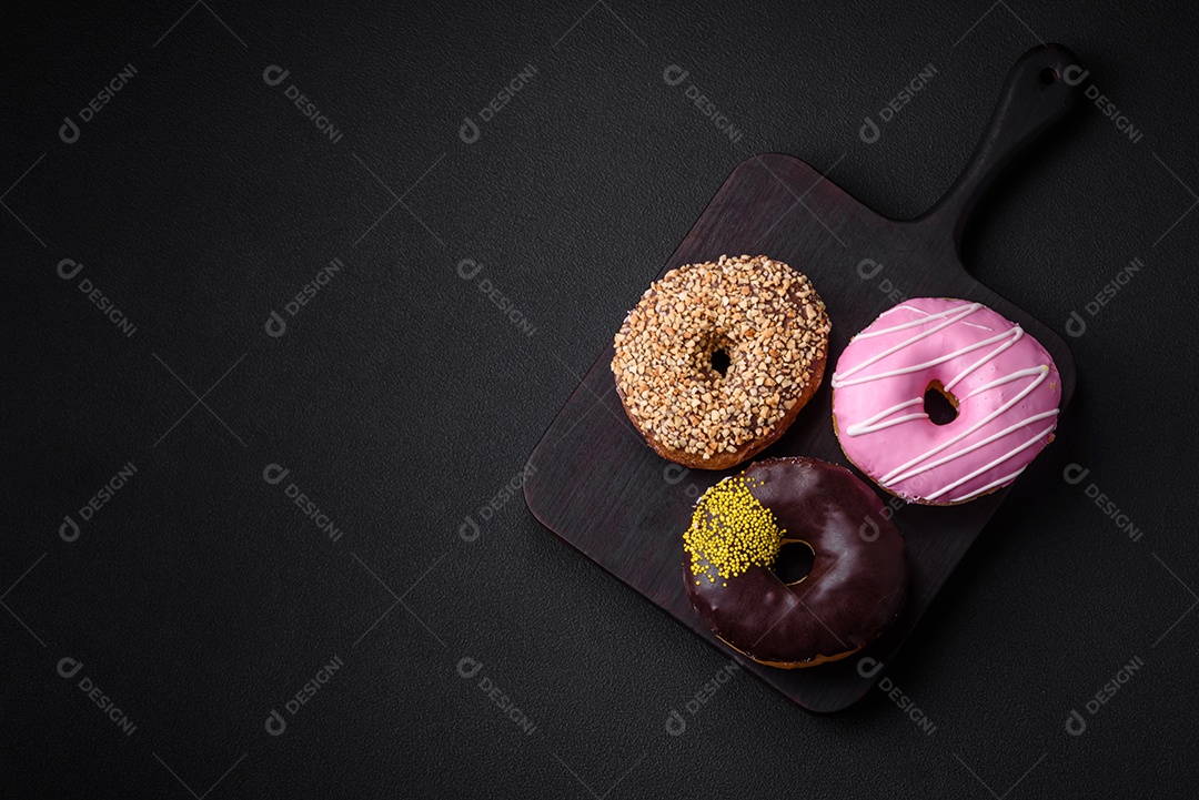 Delicioso donut com recheio de creme e nozes em um fundo escuro de concreto. Comida doce