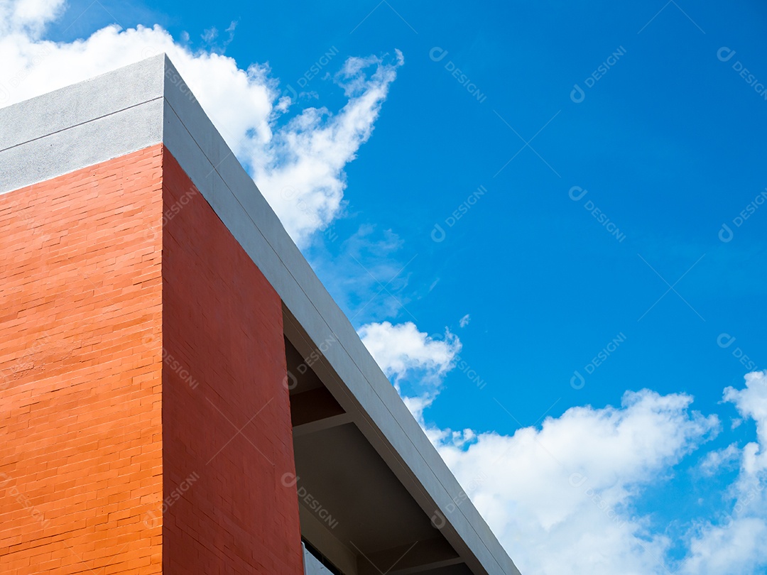 Edifício laranja sobre um fundo de céu azul e nuvens brancas.