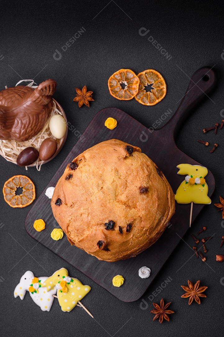Bolo de Páscoa ou panetone com passas e frutas cristalizadas sobre fundo escuro de concreto