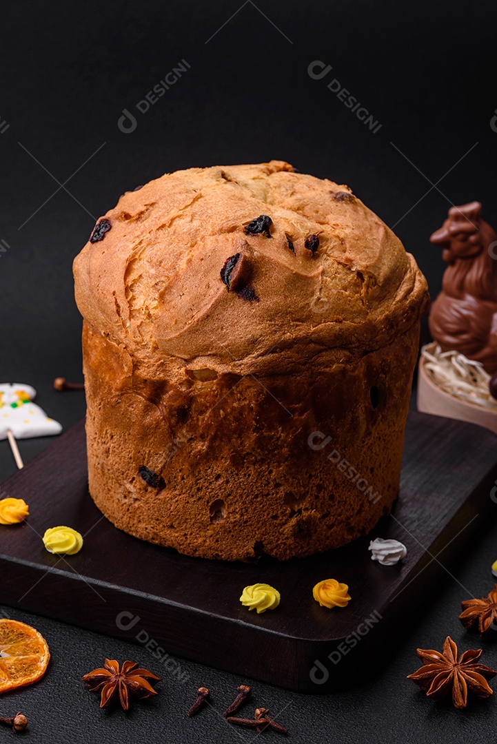 Bolo de Páscoa ou panetone com passas e frutas cristalizadas sobre fundo escuro de concreto