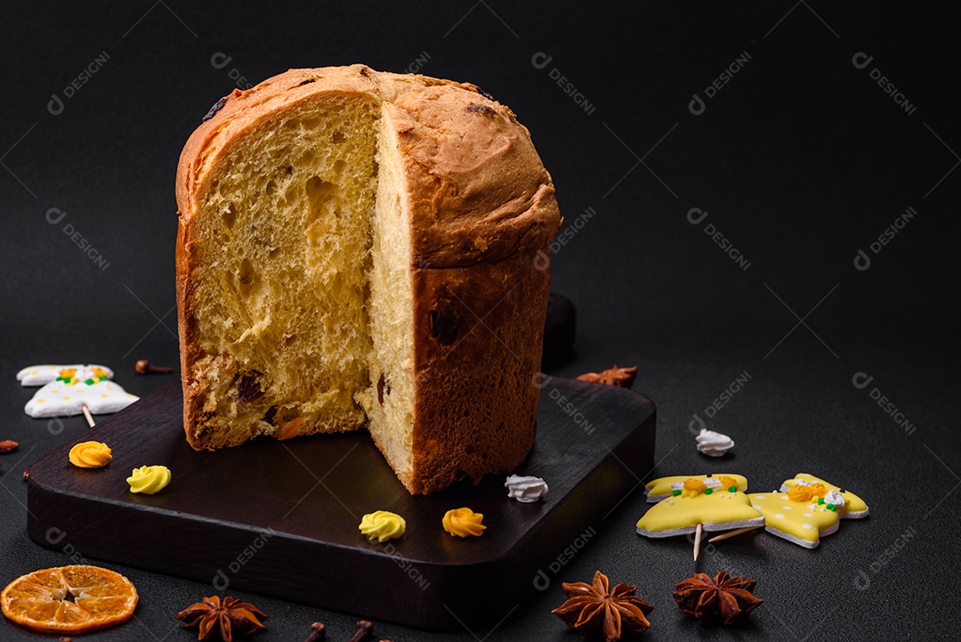 Bolo de Páscoa ou panetone com passas e frutas cristalizadas sobre fundo escuro de concreto