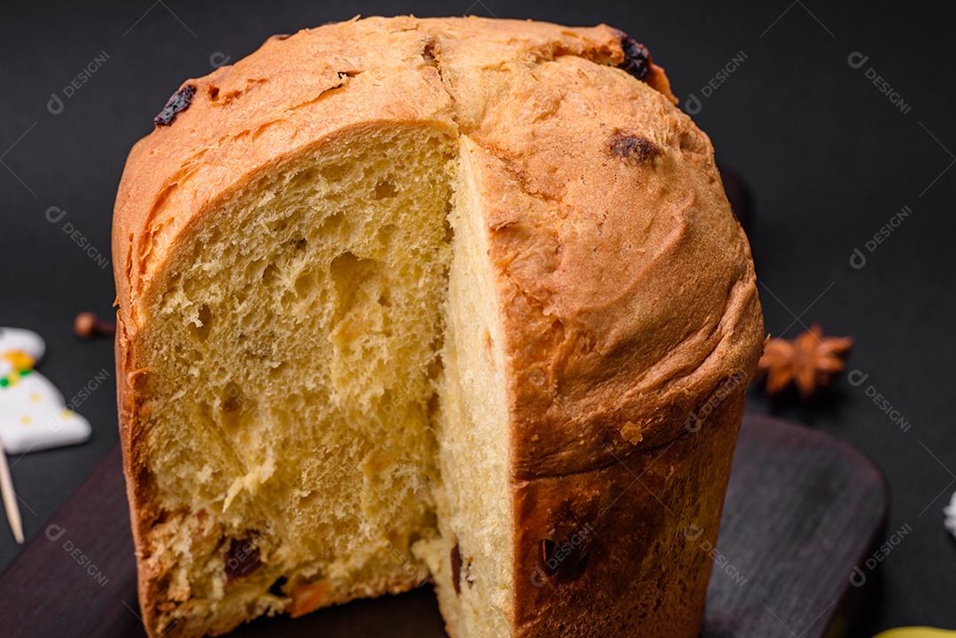 Bolo de Páscoa ou panetone com passas e frutas cristalizadas sobre fundo escuro de concreto