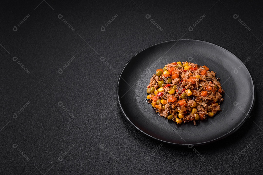 Deliciosa salada vegetariana com atum enlatado e mistura de vegetais mexicanos em fundo escuro de concreto