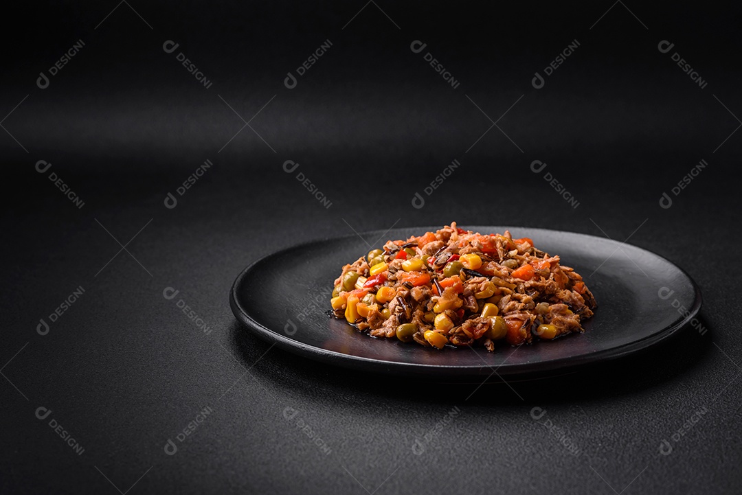 Deliciosa salada vegetariana com atum enlatado e mistura de vegetais mexicanos em fundo escuro de concreto