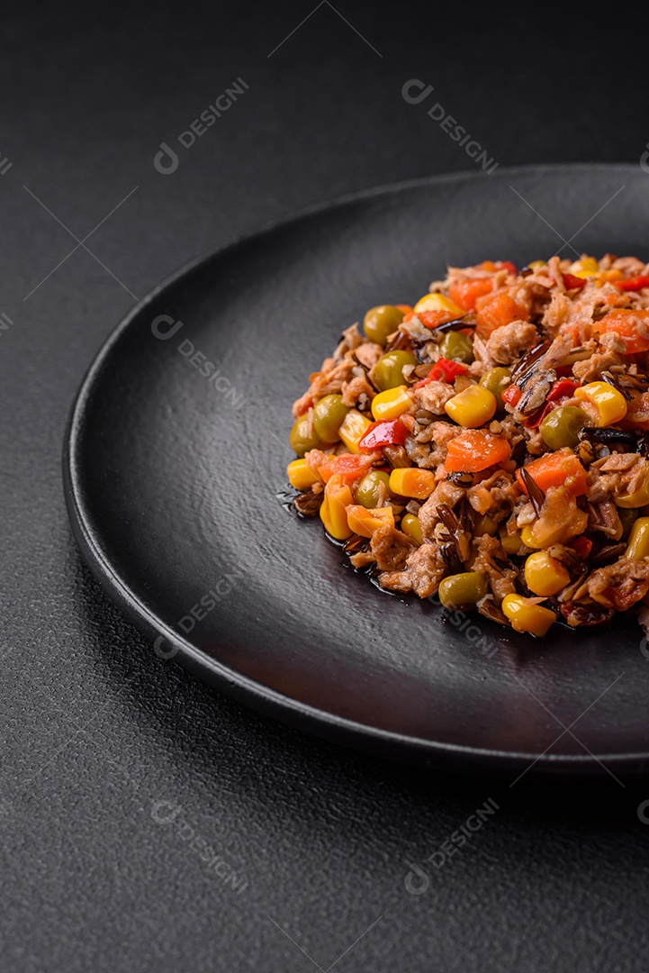 Deliciosa salada vegetariana com atum enlatado e mistura de vegetais mexicanos em fundo escuro de concreto