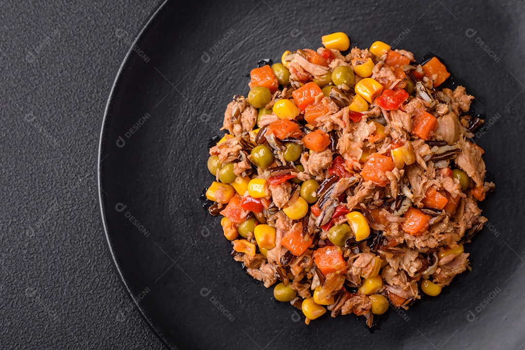 Deliciosa salada vegetariana com atum enlatado e mistura de vegetais mexicanos em fundo escuro de concreto
