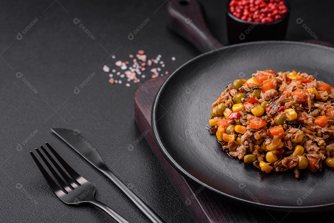 Deliciosa salada vegetariana com atum enlatado e mistura de vegetais mexicanos em fundo escuro de concreto