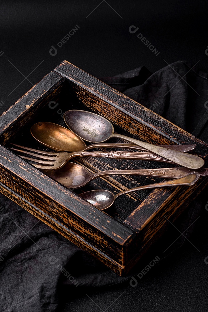 Talheres de pratas sobre caixa de madeira sobre uma mesa