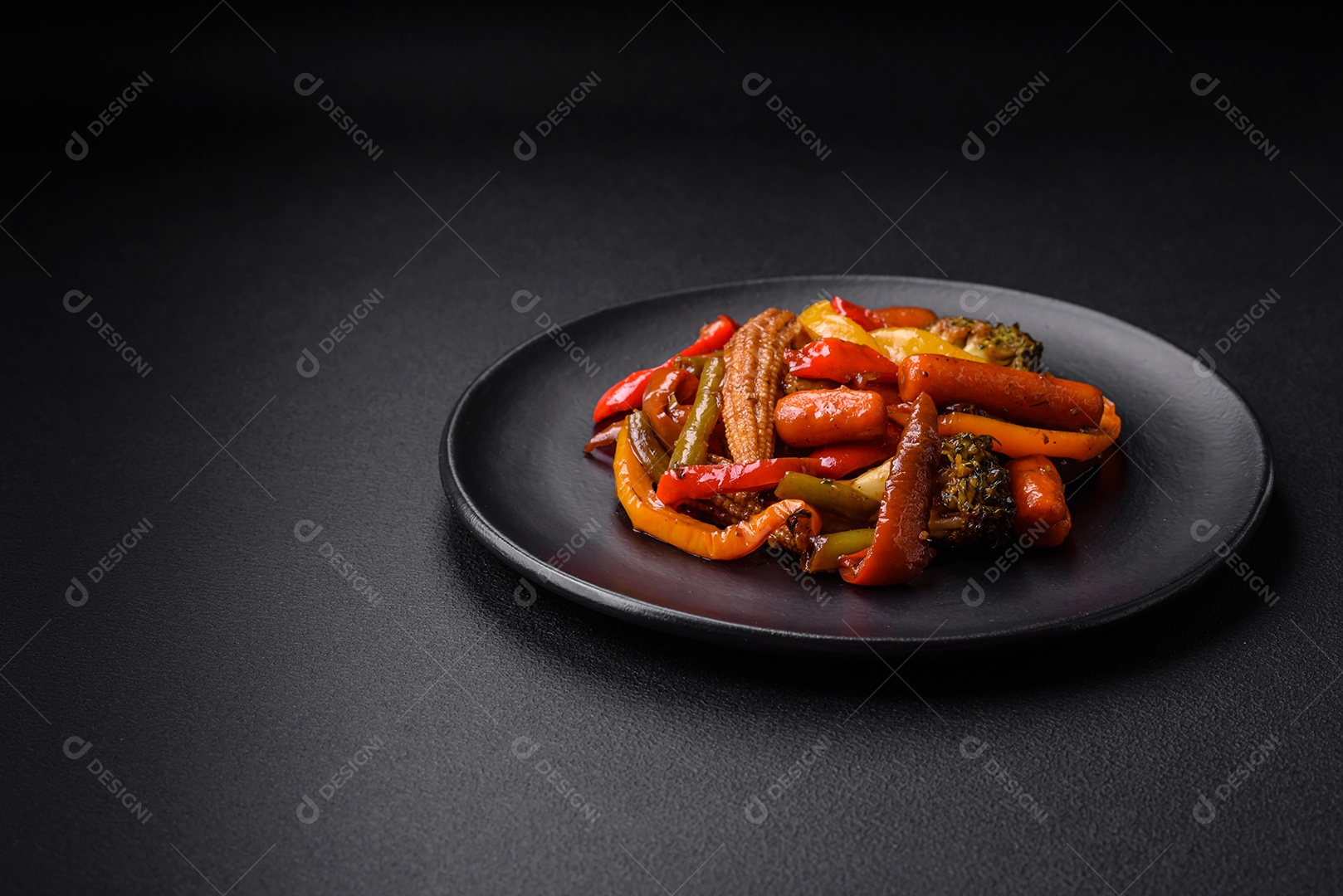 Legumes deliciosos pimentões cozidos no vapor, feijão de espargos e batatas fatiadas com molho de soja sobre um fundo escuro de concreto
