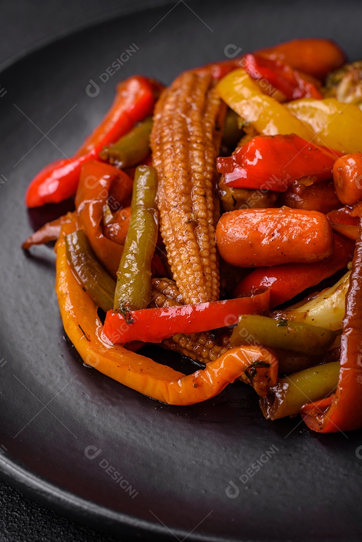 Legumes deliciosos pimentões cozidos no vapor, feijão de espargos e batatas fatiadas com molho de soja sobre um fundo escuro de concreto