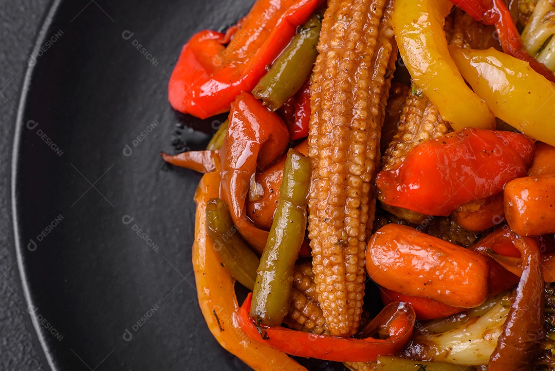 Legumes deliciosos pimentões cozidos no vapor, feijão de espargos e batatas fatiadas com molho de soja sobre um fundo escuro de concreto