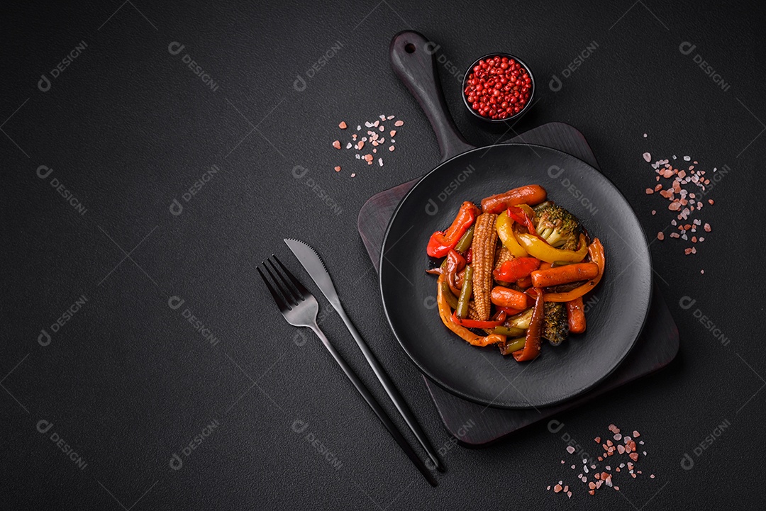 Legumes deliciosos pimentões cozidos no vapor, feijão de espargos e batatas fatiadas com molho de soja sobre um fundo escuro de concreto