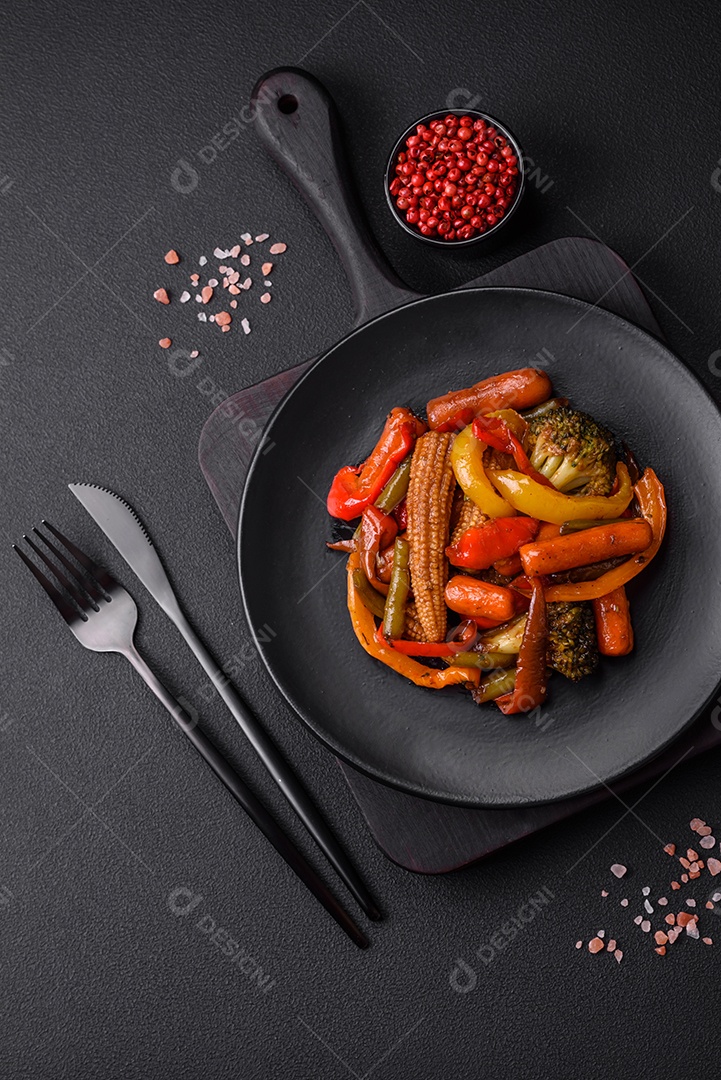 Legumes deliciosos pimentões cozidos no vapor, feijão de espargos e batatas fatiadas com molho de soja sobre um fundo escuro de concreto