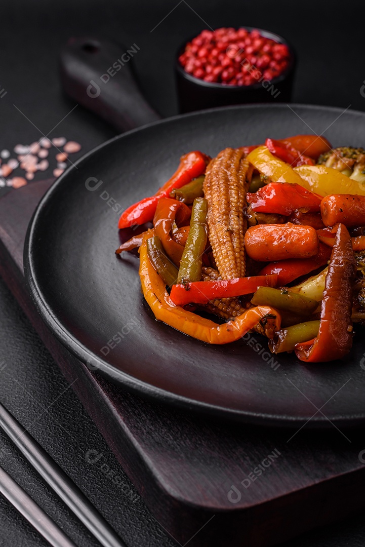 Legumes deliciosos pimentões cozidos no vapor, feijão de espargos e batatas fatiadas com molho de soja sobre um fundo escuro de concreto