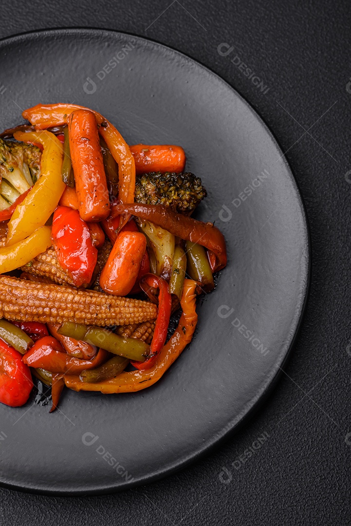 Legumes deliciosos pimentões cozidos no vapor, feijão de espargos e batatas fatiadas com molho de soja sobre um fundo escuro de concreto