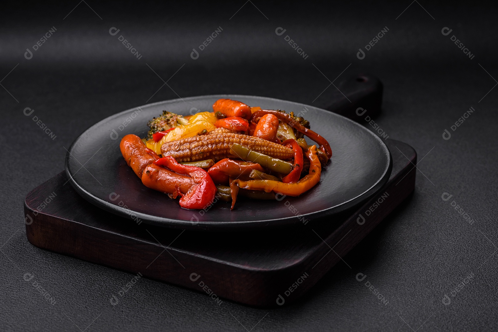 Legumes deliciosos pimentões cozidos no vapor, feijão de espargos e batatas fatiadas com molho de soja sobre um fundo escuro de concreto