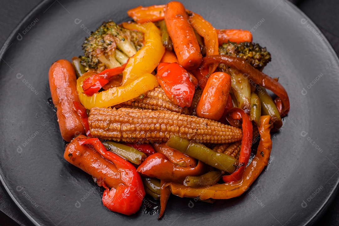 Legumes deliciosos pimentões cozidos no vapor, feijão de espargos e batatas fatiadas com molho de soja sobre um fundo escuro de concreto