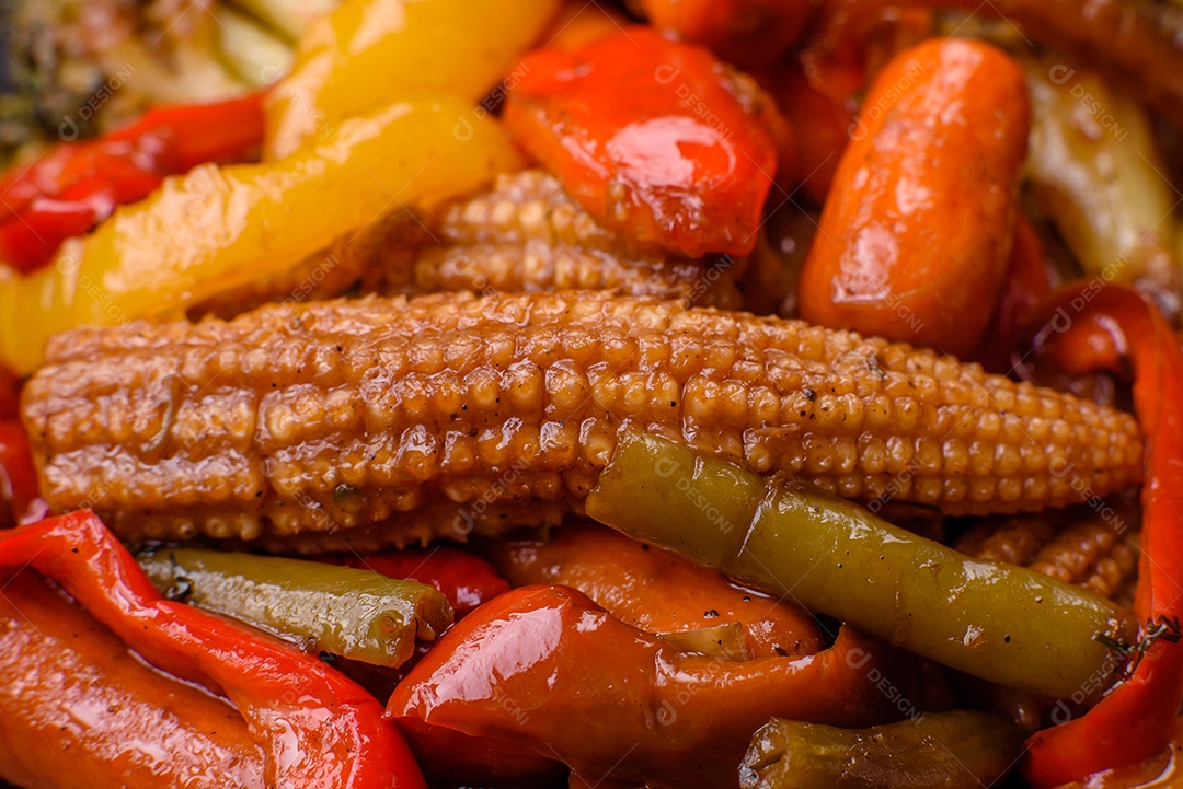 Legumes deliciosos pimentões cozidos no vapor, feijão de espargos e batatas fatiadas com molho de soja sobre um fundo escuro de concreto