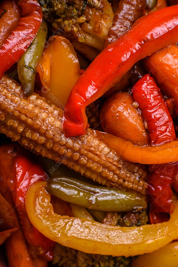 Legumes deliciosos pimentões cozidos no vapor, feijão de espargos e batatas fatiadas com molho de soja sobre um fundo escuro de concreto