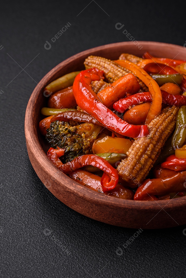 Legumes deliciosos pimentões cozidos no vapor, feijão de espargos e batatas fatiadas com molho de soja sobre um fundo escuro de concreto