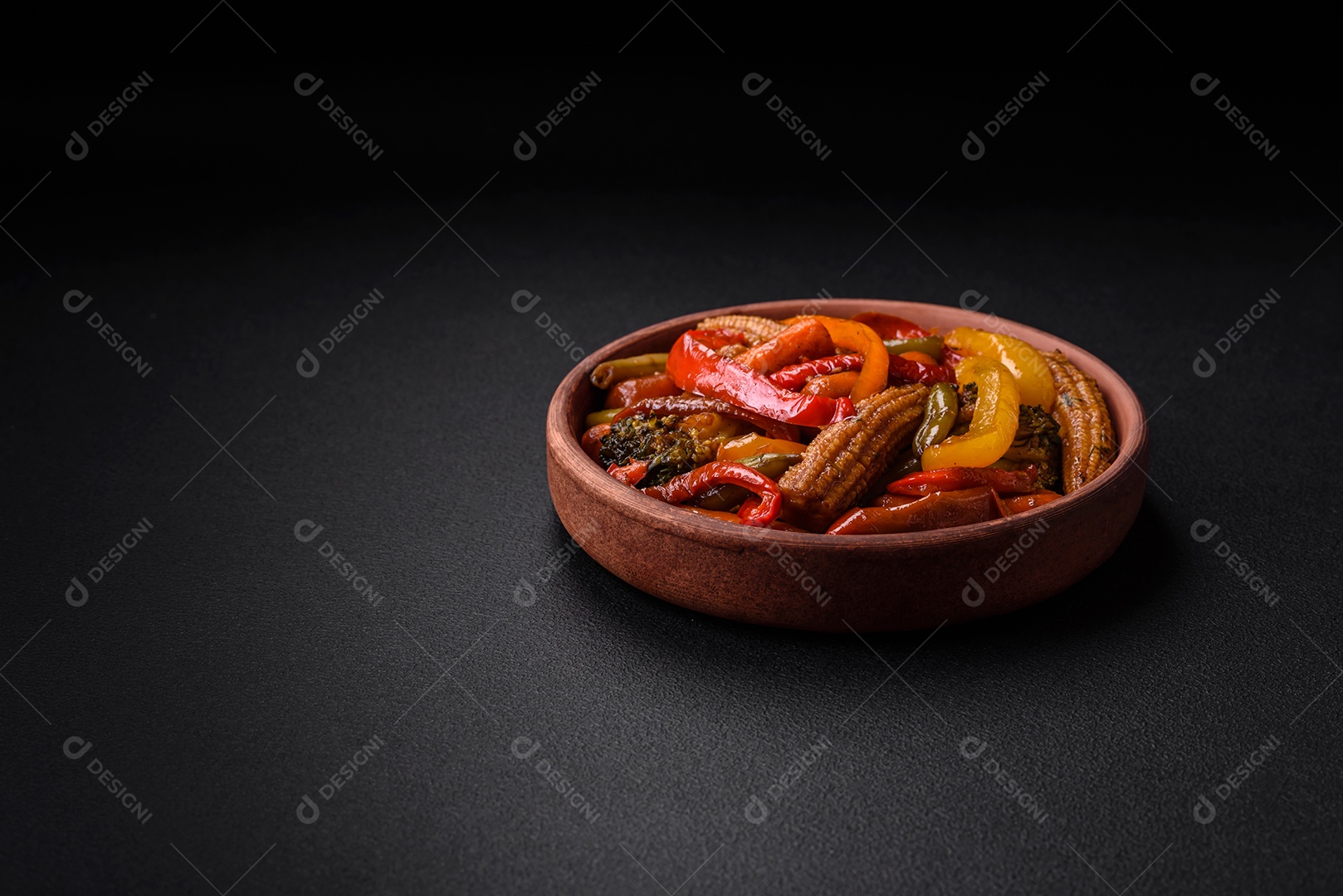 Legumes deliciosos pimentões cozidos no vapor, feijão de espargos e batatas fatiadas com molho de soja sobre um fundo escuro de concreto