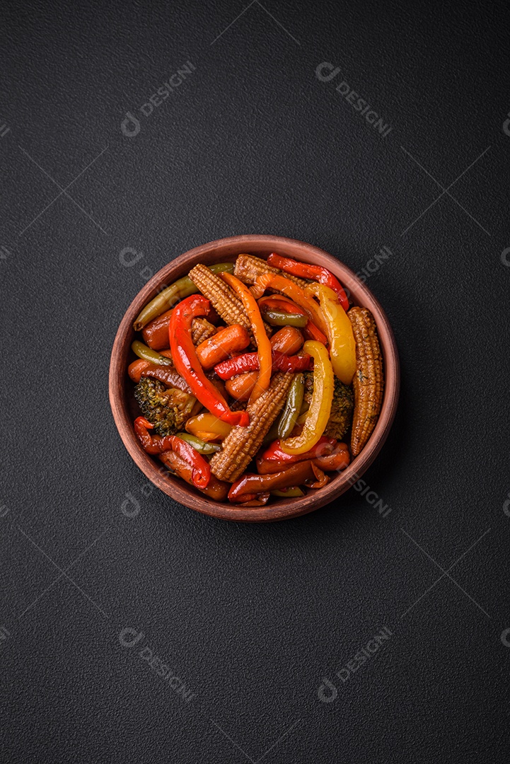 Legumes deliciosos pimentões cozidos no vapor, feijão de espargos e batatas fatiadas com molho de soja sobre um fundo escuro de concreto