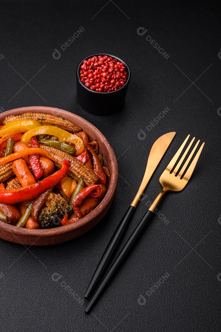 Legumes deliciosos pimentões cozidos no vapor, feijão de espargos e batatas fatiadas com molho de soja sobre um fundo escuro de concreto