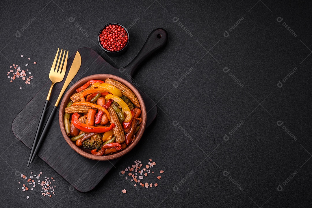 Legumes deliciosos pimentões cozidos no vapor, feijão de espargos e batatas fatiadas com molho de soja sobre um fundo escuro de concreto