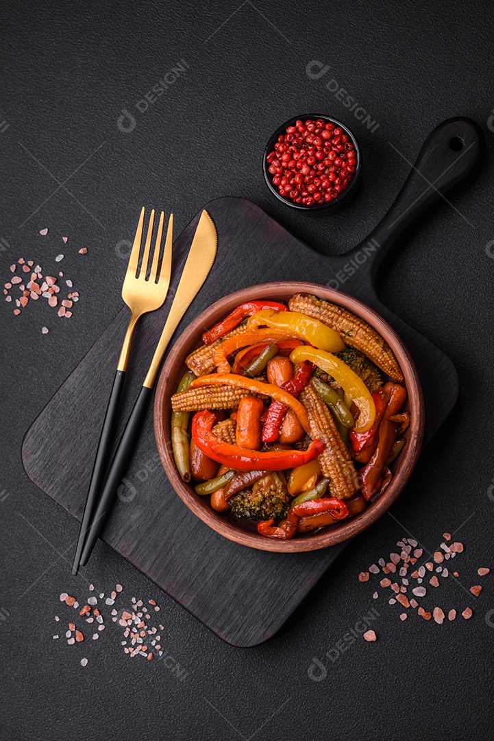 Legumes deliciosos pimentões cozidos no vapor, feijão de espargos e batatas fatiadas com molho de soja sobre um fundo escuro de concreto