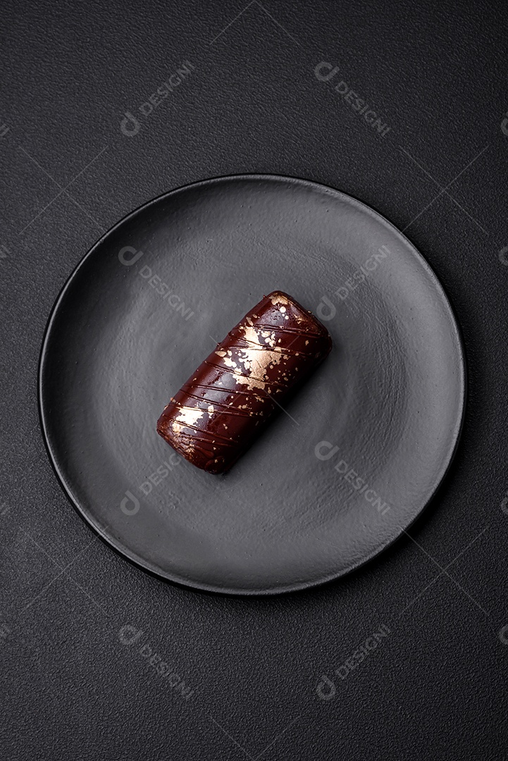 Delicioso queijo doce com calda coberta com chocolate e nozes em uma placa de cerâmica sobre um fundo escuro de concreto