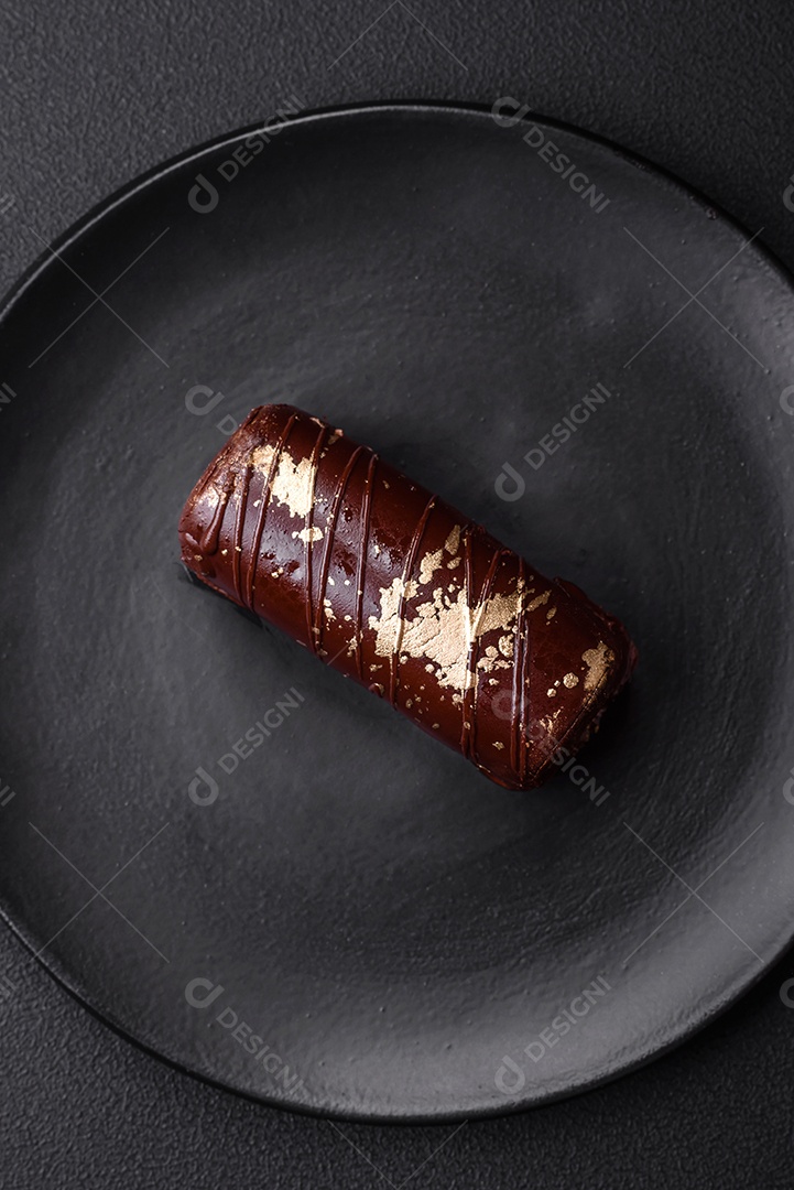 Delicioso queijo doce com calda coberta com chocolate e nozes em uma placa de cerâmica sobre um fundo escuro de concreto