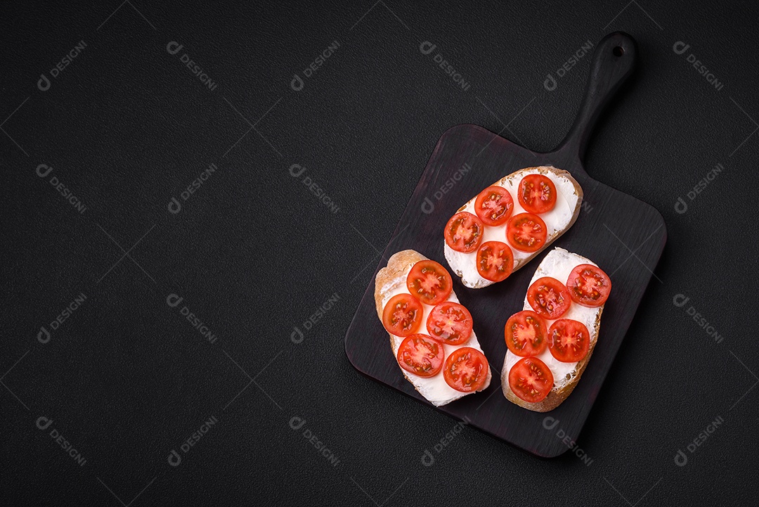 Deliciosa torrada grelhada crocante com queijo e tomate cereja em um fundo escuro de concreto