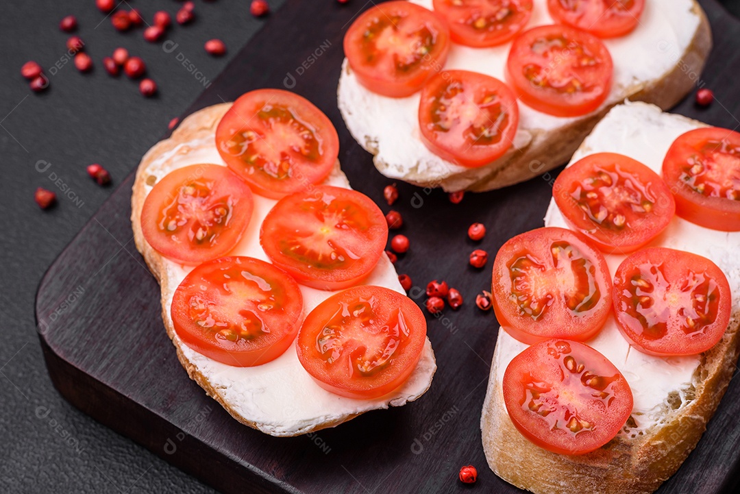 Deliciosa torrada grelhada crocante com queijo e tomate cereja em um fundo escuro de concreto