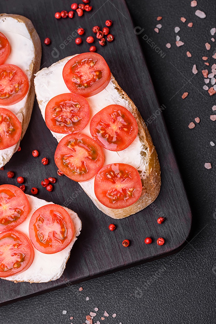 Deliciosa torrada grelhada crocante com queijo e tomate cereja em um fundo escuro de concreto