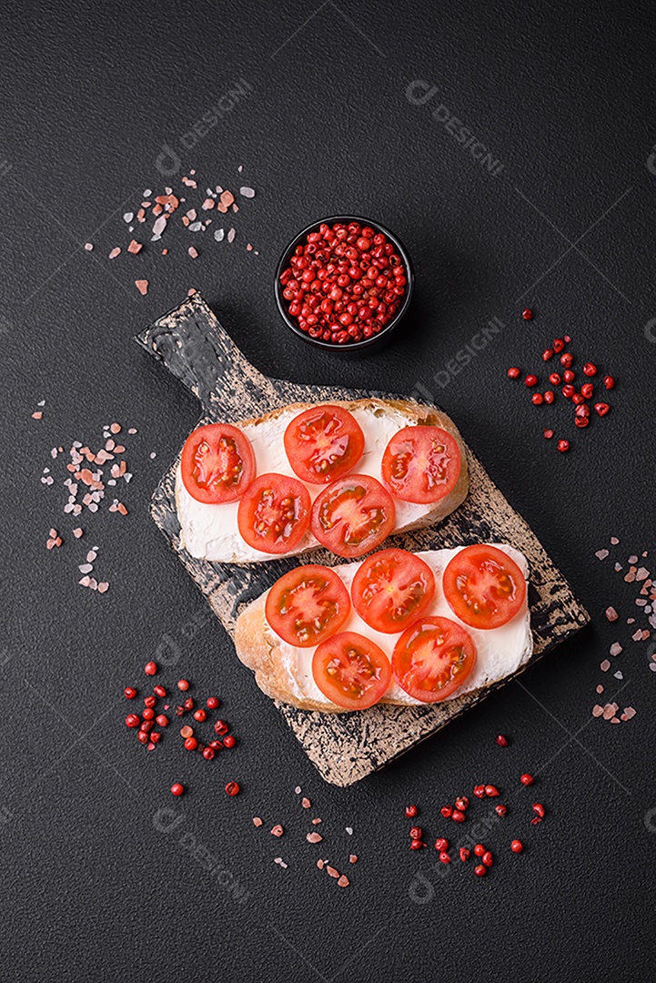 Deliciosa torrada grelhada crocante com queijo e tomate cereja em um fundo escuro de concreto