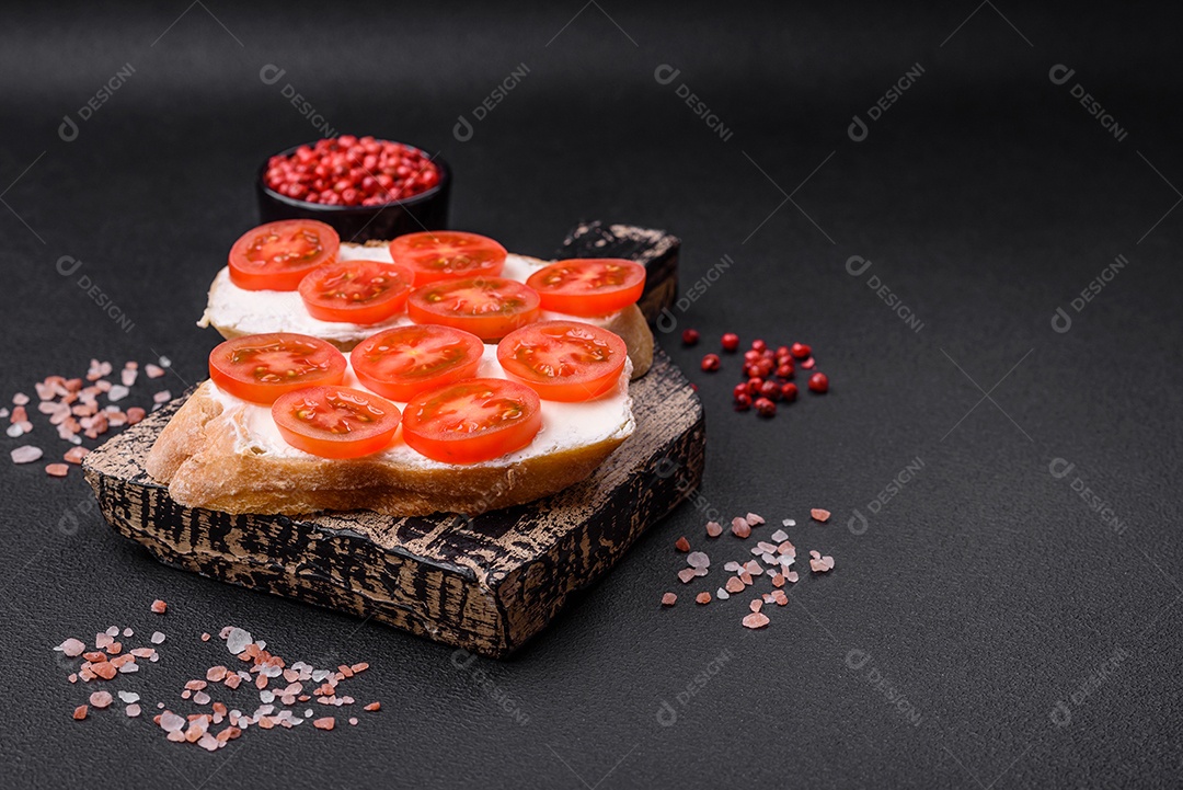 Deliciosa torrada grelhada crocante com queijo e tomate cereja em um fundo escuro de concreto
