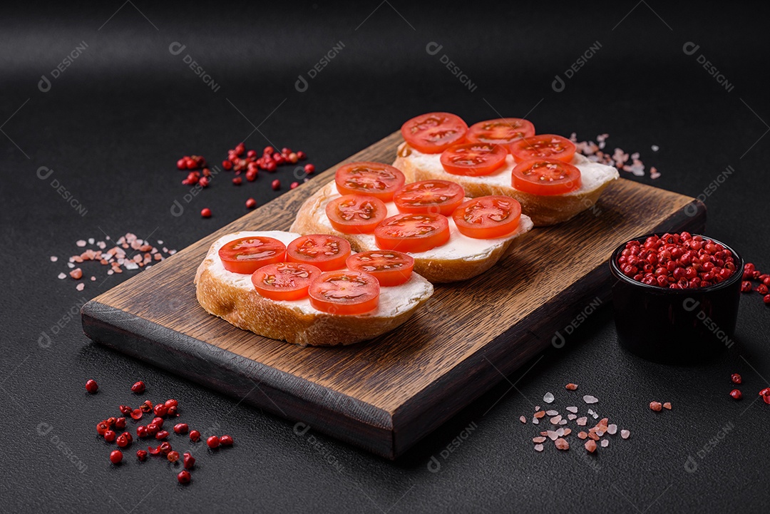 Deliciosa torrada grelhada crocante com queijo e tomate cereja em um fundo escuro de concreto