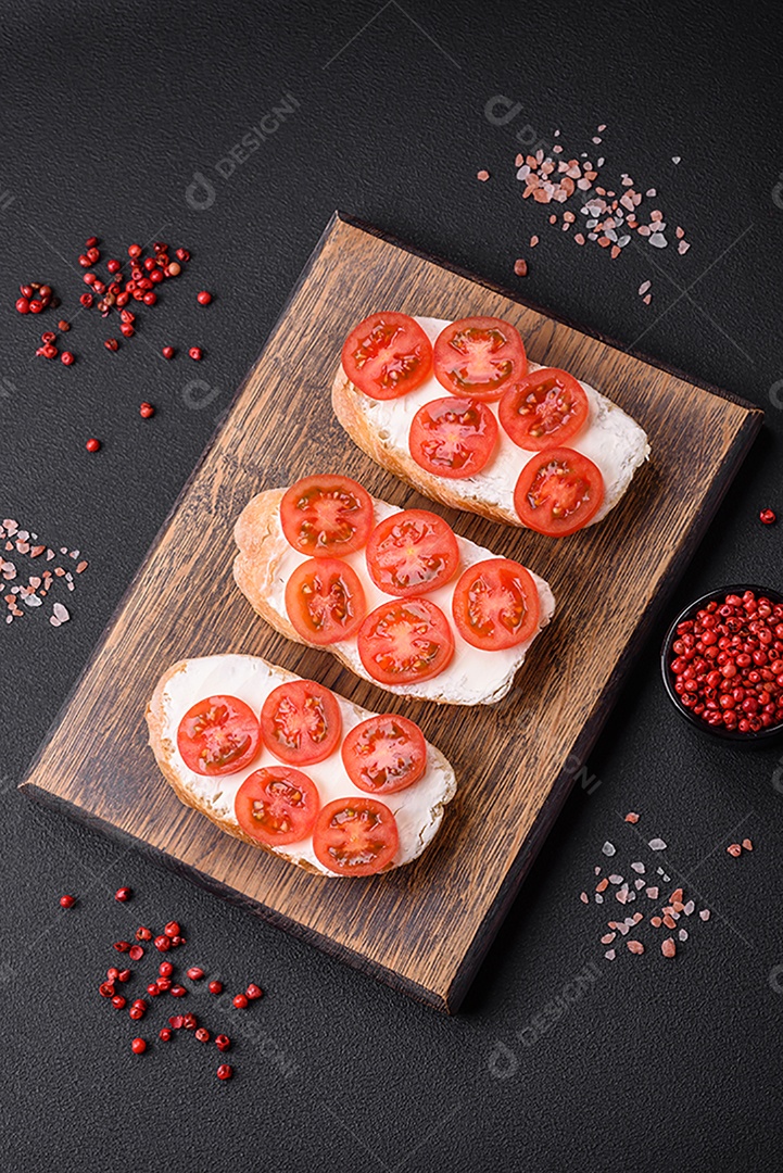 Deliciosa torrada grelhada crocante com queijo e tomate cereja em um fundo escuro de concreto