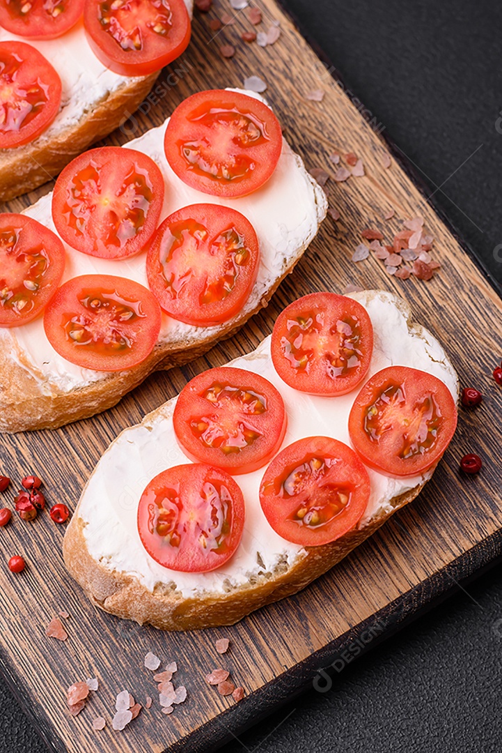 Deliciosa torrada grelhada crocante com queijo e tomate cereja em um fundo escuro de concreto