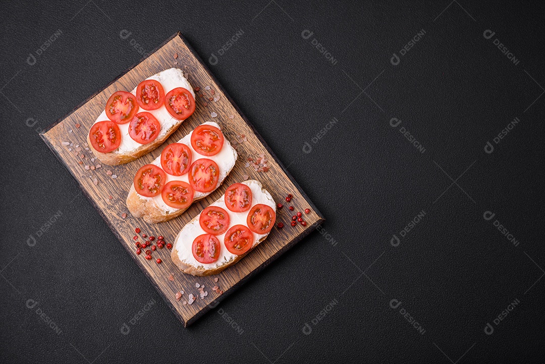 Deliciosa torrada grelhada crocante com queijo e tomate cereja em um fundo escuro de concreto