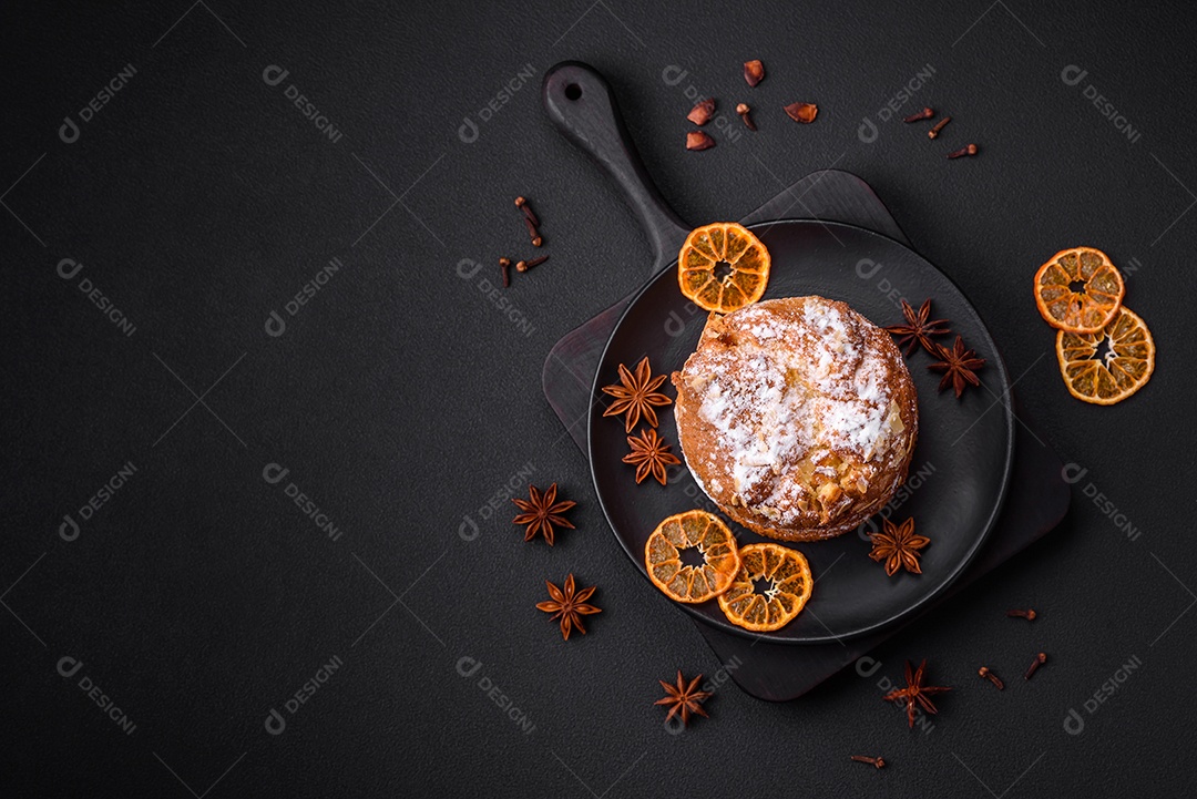 Delicioso bolo de Páscoa fresco com frutas e passas em um fundo escuro de concreto