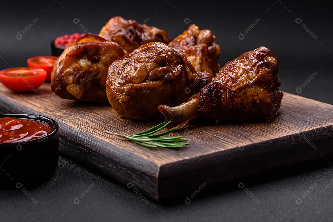 Deliciosas pernas de frango grelhado com especiarias e ervas em molho teriyaki sobre um fundo escuro de concreto