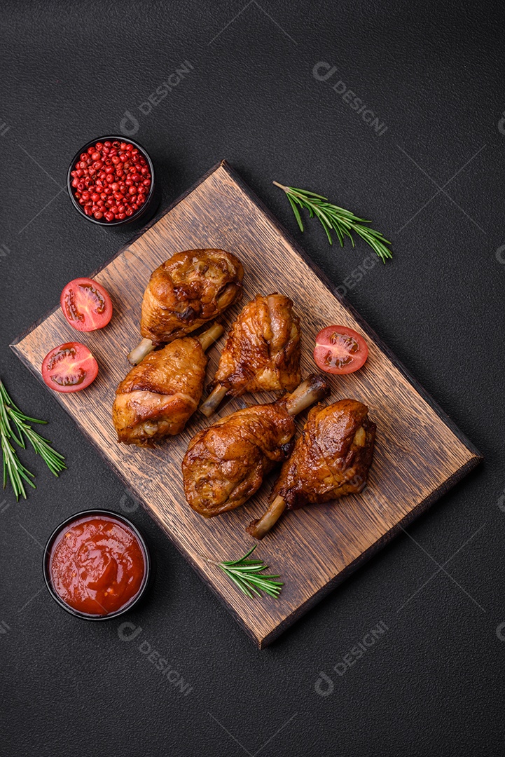 Deliciosas pernas de frango grelhado com especiarias e ervas em molho teriyaki sobre um fundo escuro de concreto